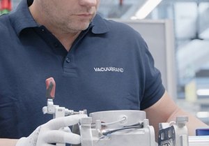 An employee assembles a vacuum pump.